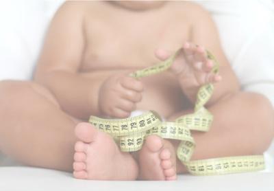 Kid with measuring tape. Smiling kid looking at numbers on tape measure.  Concept of measuring height or growing tall Stock Photo