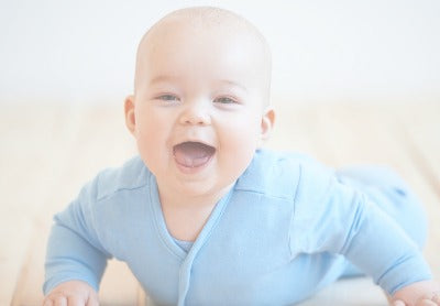 Portrait of smiling baby boy playing with thermostat of heater Stock Photo